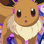 An image of Eevee on top of several Pokemon TCG cards piled up face down