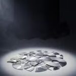 Broken video game discs with an Xbox in the background